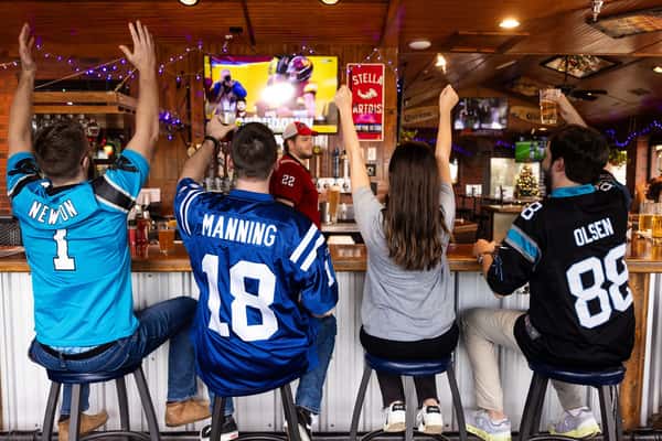 Guests cheering while watching a game at the bar