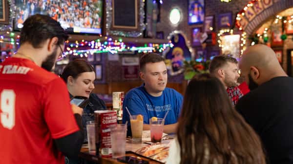 Group of people enjoy food and cocktails during the holidays at Carolina Ale House
