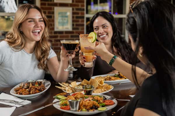 Women enjoying cocktails and food at Carolina Ale House