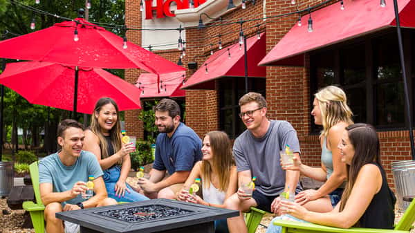 Group of friends celebrating on the patio at Carolina Ale House