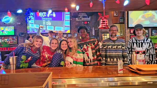 Group of people at the bar celebrating the holidays at Carolina Ale House