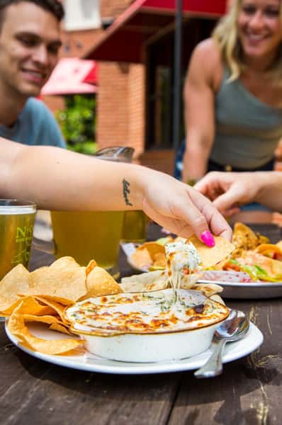 Guest enjoying tortilla chips with a hot housemade dip