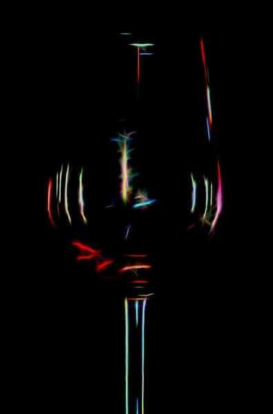 Abstract neon outlines of a wine glass glowing in the dark with multicolored light streaks and reflections.