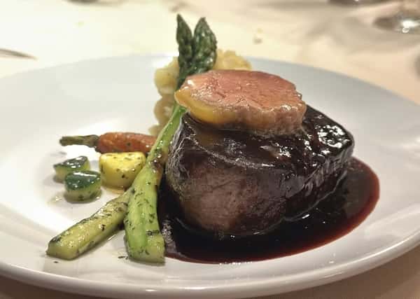 Filet mignon topped with foie gras, served with asparagus, glazed vegetables, and a rich red wine reduction sauce.
