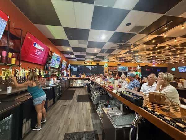 Full bar of people enjoying good company and watching sports on tv