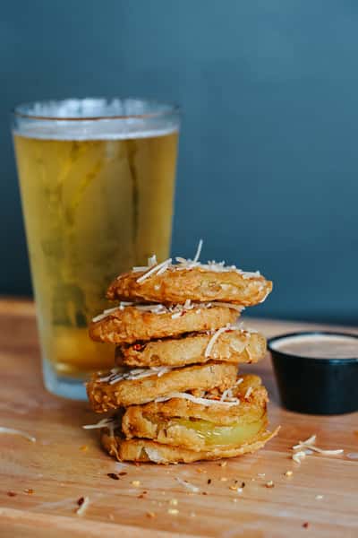 Stacked fried green tomatoes topped with grated Parmesan and served with a creamy dipping sauce.
