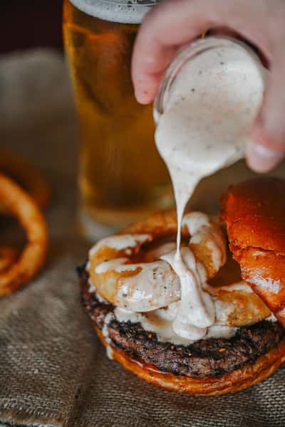 Cajun ranch burger topped with crispy onion straws and creamy ranch sauce on a toasted brioche bun.