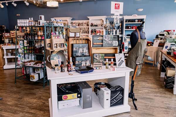 Vendor display booth with kitchen goods, home decor, and artisan products at an indoor market event