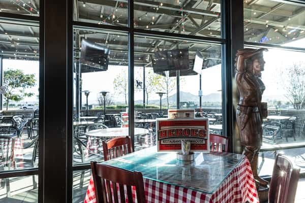 restaurant dining area with large windows, waterfront views, and modern rustic seating