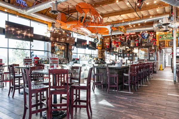 restaurant bar interior with illuminated liquor shelves, colorful decor, and casual seating