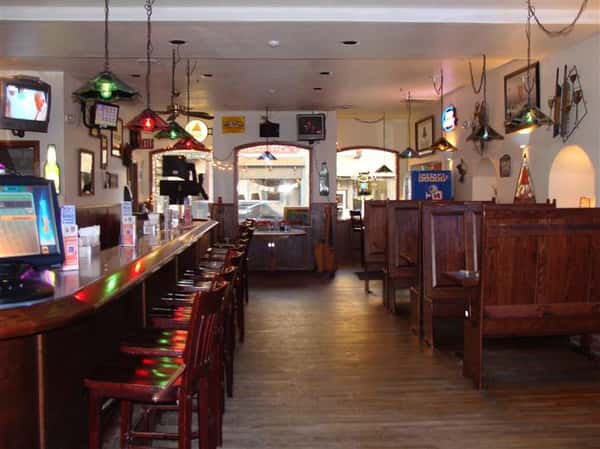 Bar area of establishment with dining area to the side