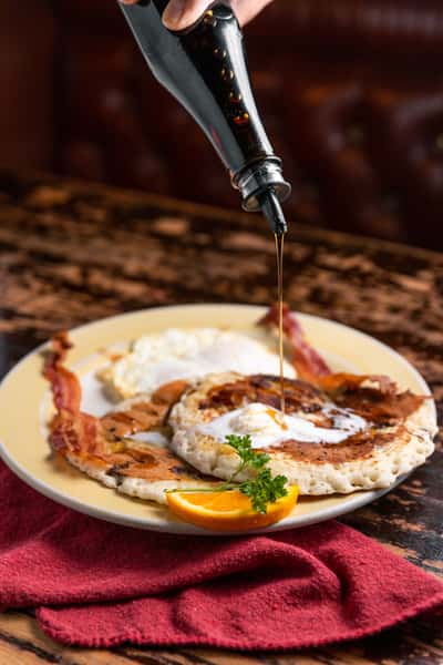 pouring syrup on pancakes