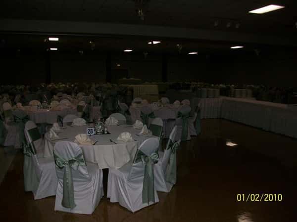 Different section of tables with big ribbons on chairs
