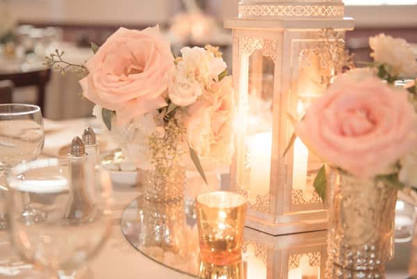 white and pink wedding reception center piece with flowers and candles