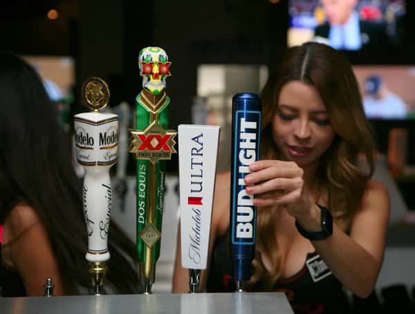 Bartender pouring draft beer from Modelo, Dos Equis, Michelob Ultra and Bud Light taps at sports bar counter