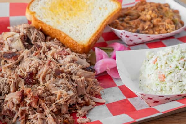 Chopped BBQ pork plate with white bread and coleslaw served on red and white checkered paper at North Georgia BBQ restaurant