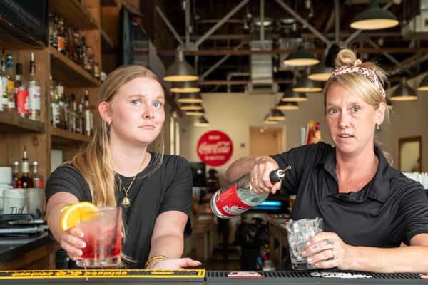 Bartenders preparing drinks inside North Georgia BBQ, showcasing friendly service and lively atmosphere