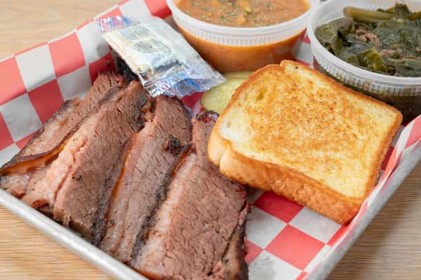 BBQ brisket plate served with white bread and sides on red and white checkered paper in a metal tray at North Georgia BBQ restaurant