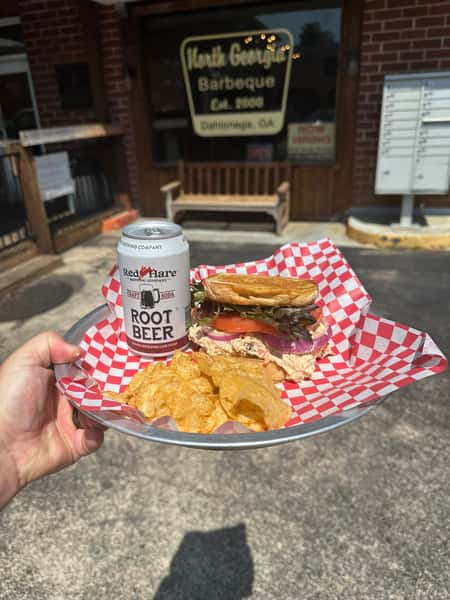 Smoked pork sandwich with chips and root beer served outside North Georgia Barbeque in Dahlonega GA