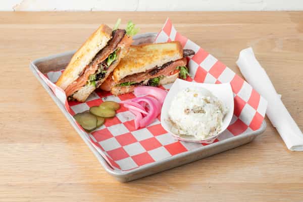 Grilled salmon BLT sandwich with lettuce, tomato, and pickled onions at North Georgia BBQ restaurant
