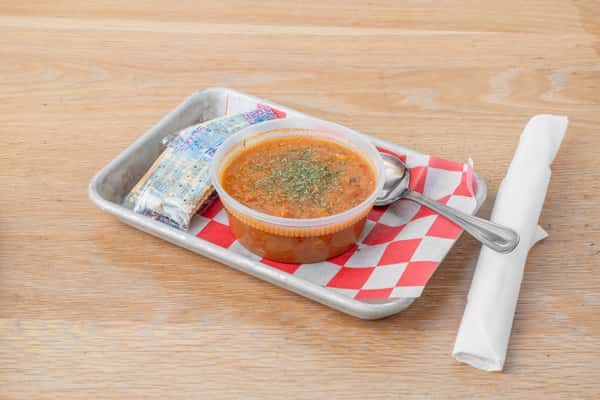 A bowl of hearty BBQ stew served in a metal tray on red and white checkered paper at North Georgia BBQ restaurant