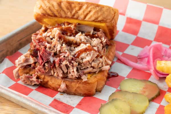 The Pig Melt sandwich piled high with smoked pulled pork and melted cheese at North Georgia BBQ