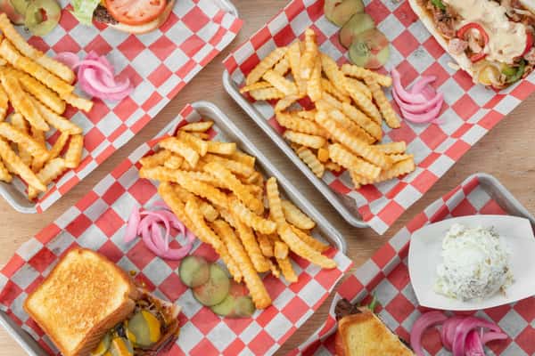 Overhead view of a menu item with crinkle-cut fries and a sandwich served on red and white checkered paper in a tray at North Georgia BBQ restaurant
