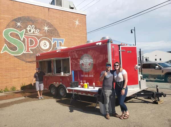 couple posing in front of Food Truck