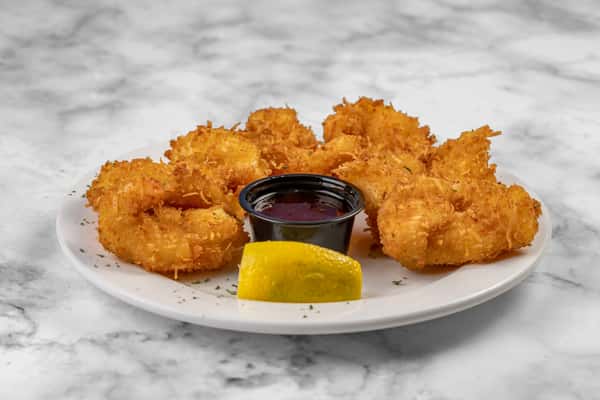Golden coconut shrimp arranged around a small cup of sweet dipping sauce with a lemon wedge — a crispy appetizer on a round white plate.