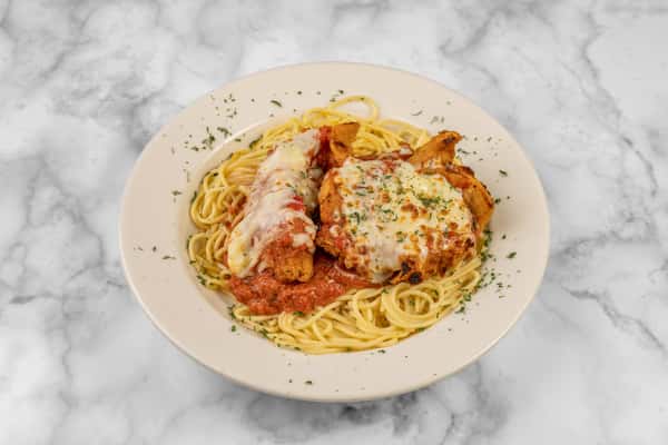 Plate of crispy chicken Parmesan topped with marinara and melted mozzarella, served over a bed of spaghetti and garnished with parsley — a hearty Italian-American dish.