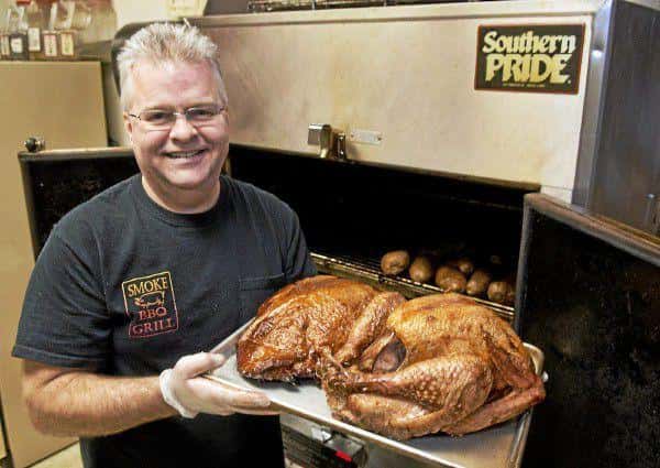 Jim Payne takes a smoked turkey and ham out of the smoker at Smoke BBQ Grill in Painesville Township. Payne uses apple wood from local orchards to smoke the meat.