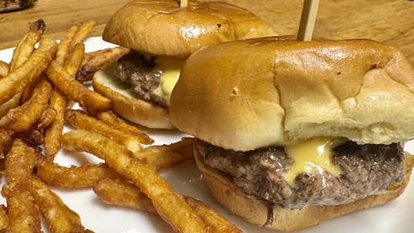 Classic cheeseburger with melted cheese served alongside golden French fries.