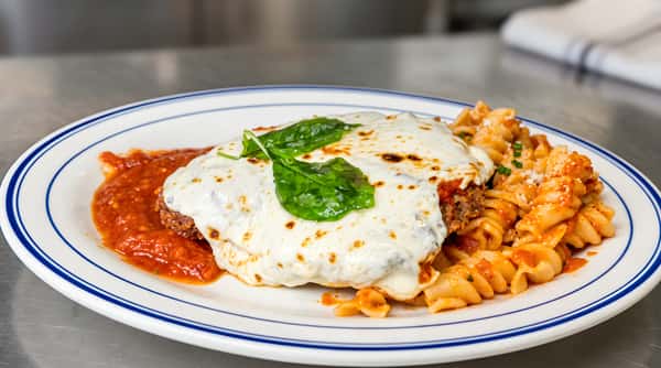Chicken parmesan with melted mozzarella, basil, tomato sauce, and fusilli pasta.