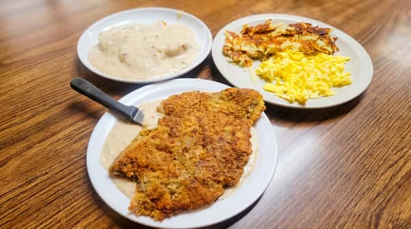 Chicken fried steak with gravy, biscuits, hash browns, and scrambled eggs.