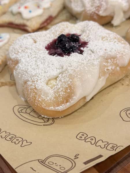 Indulge in our soft Cream Cheese Danish, filled with a rich and tangy cream cheese center. Topped with blueberry topping