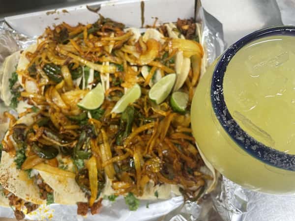 steak, peppers, and onions with a margarita