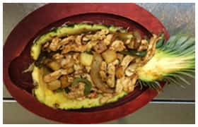 chicken, rice, peppers, and onions in a pineapple