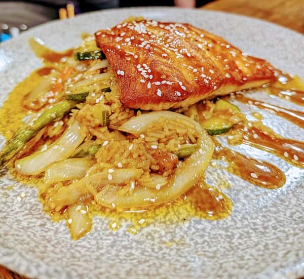 Pan seared salmon over a veggie stir fry with an Asian sesame glaze