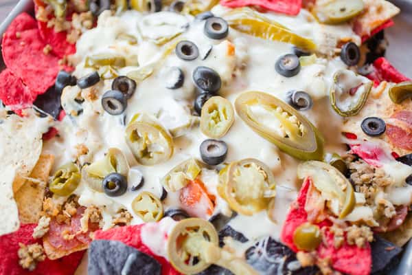 nachos with chips, jalapenos, olives and cheese