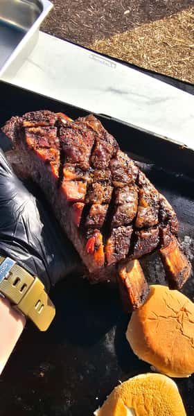 A couple ribs being held in a hand