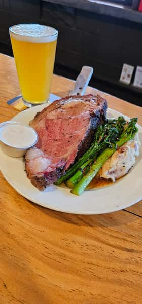 A steak on a plate with greens and mashed potatoes
