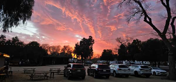 A beautiful sunset with cars parked