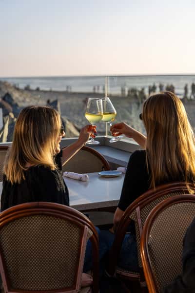2 women clinking glass of wine
