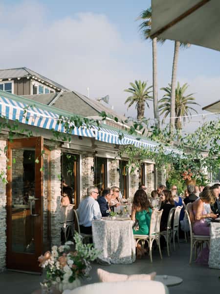 Guests attending a wedding reception outdoors at Poseidon on the Beach