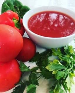 assortment of tomatoes with a side of sauce and fresh parsley