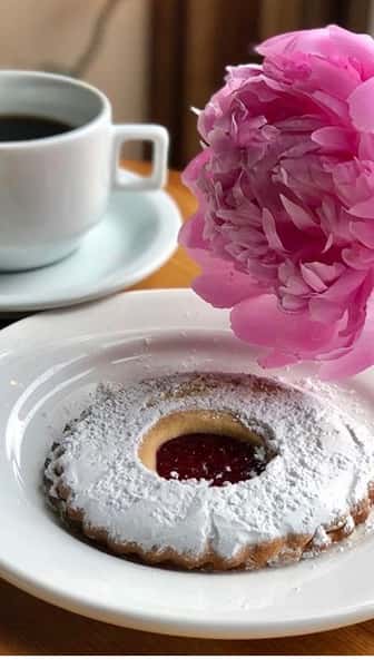 Linzer torte with a flower and a cup of coffee