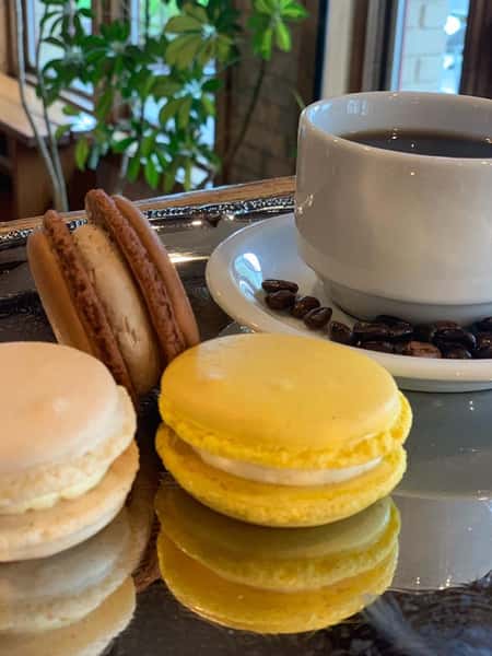 assortment of macaroons with coffee cup with coffee beans on a dish