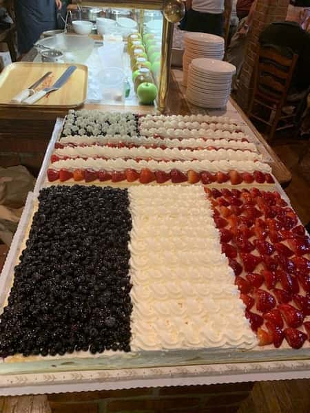 Assortment of strawberries, blueberries, and whipped cream in the shape of an American and French Flag