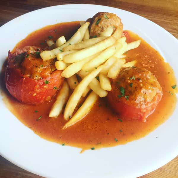 3 meatballs topped with fries in sauce on a dish