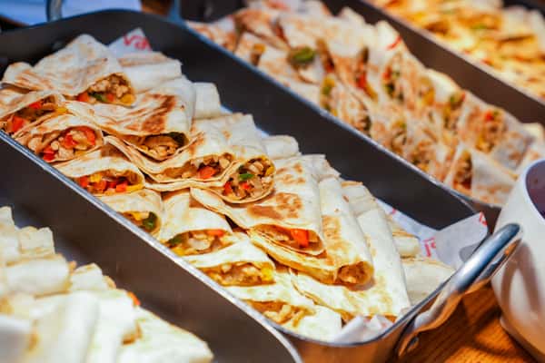 Appetizing quesadillas served in metal trays, filled with vegetables and ready for a meal.